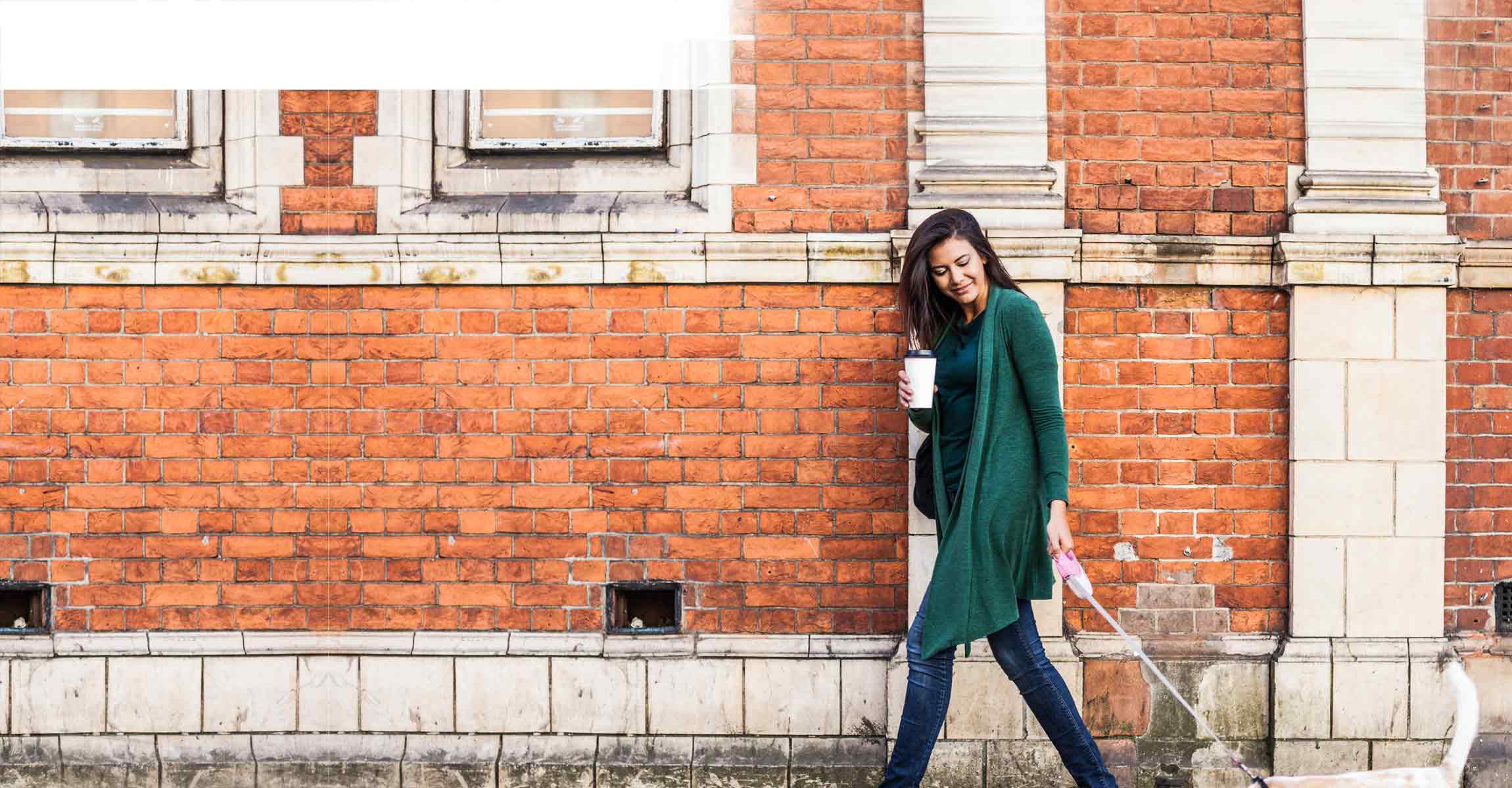 woman next to wall with coffee and dog