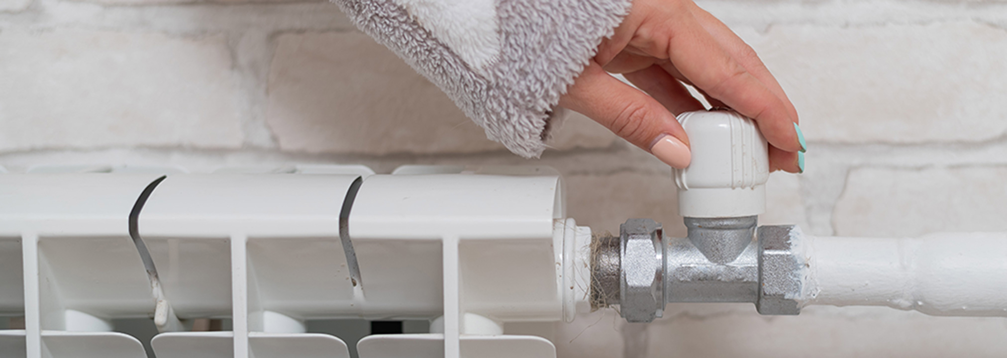 woman adjusting radiator thermostat