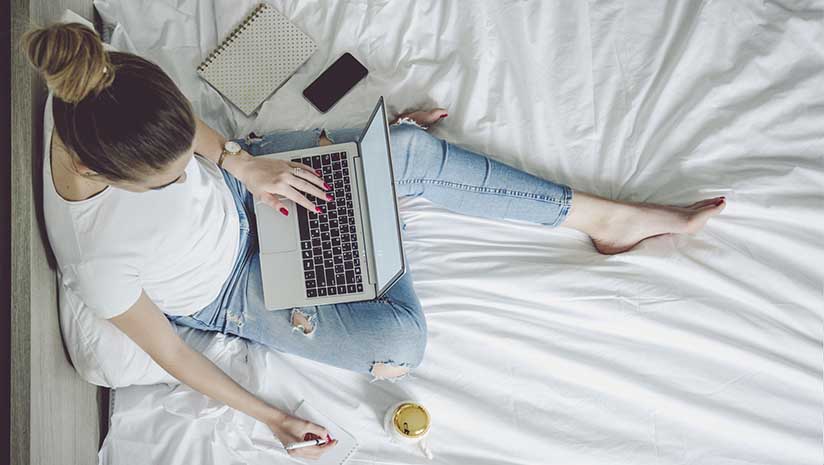 woman making notes from laptop