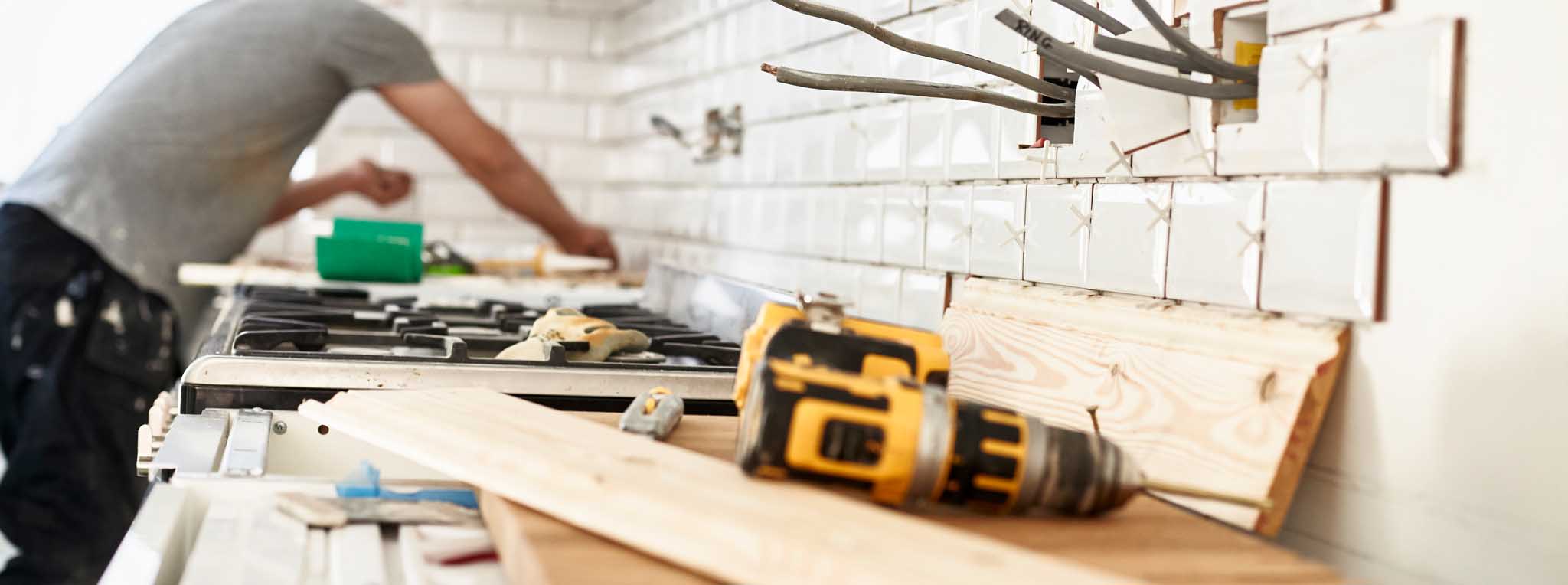 person tiling kitchen