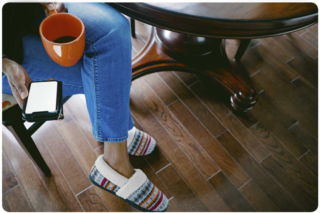 Woman holding cup of tea and phone