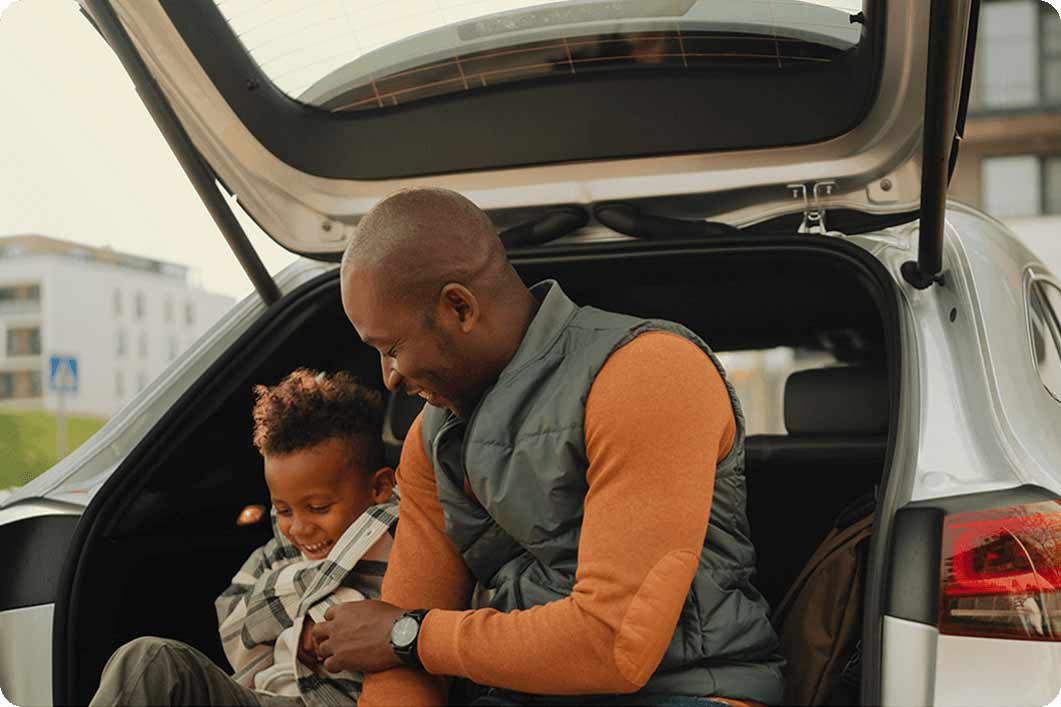 father and son sitting on tailgate of car