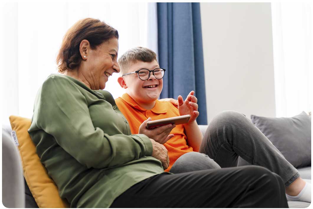 Woman and boy sat on sofa using phone