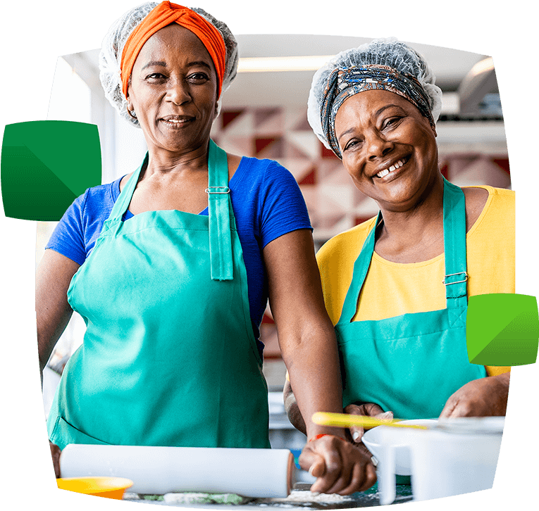 Two smiling women in aprons