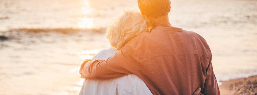 older couple embracing facing away from camera